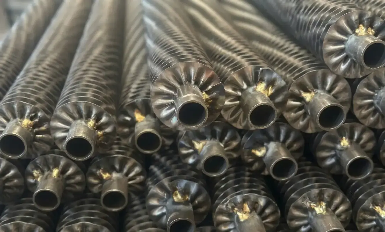 Close up stack of industrial crimped finned tubes showcasing helically wrapped spirally crimped fins mechanically attached for heavy duty radiators